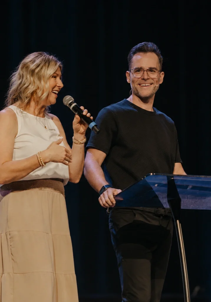 Jeremy and Lindsey Bosma smiling while preaching at Avenue Church